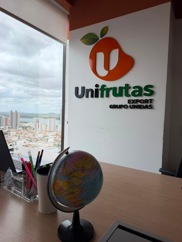 Escritório da Unifrutas com a logo na parede e vista para a cidade
